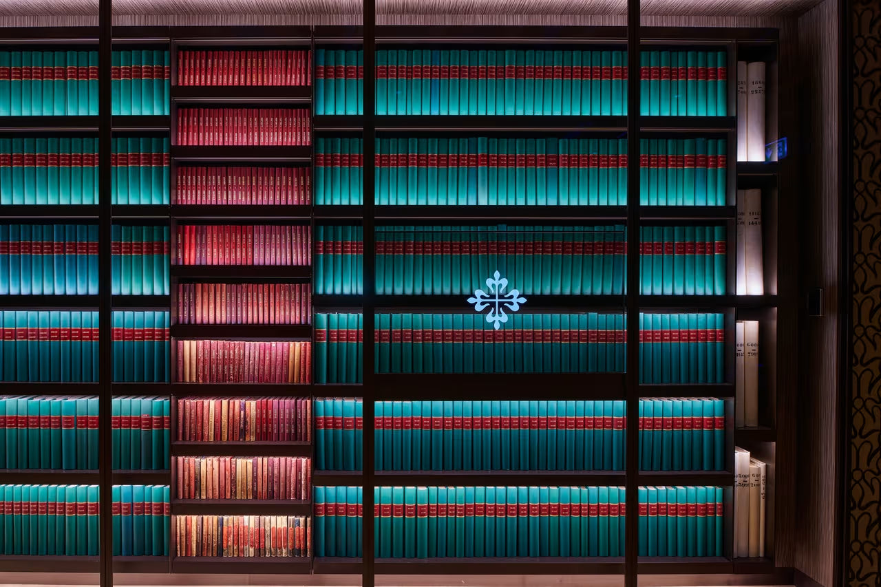 Bookshelf with books arranged in a decorative pattern, featuring a central light fixture.